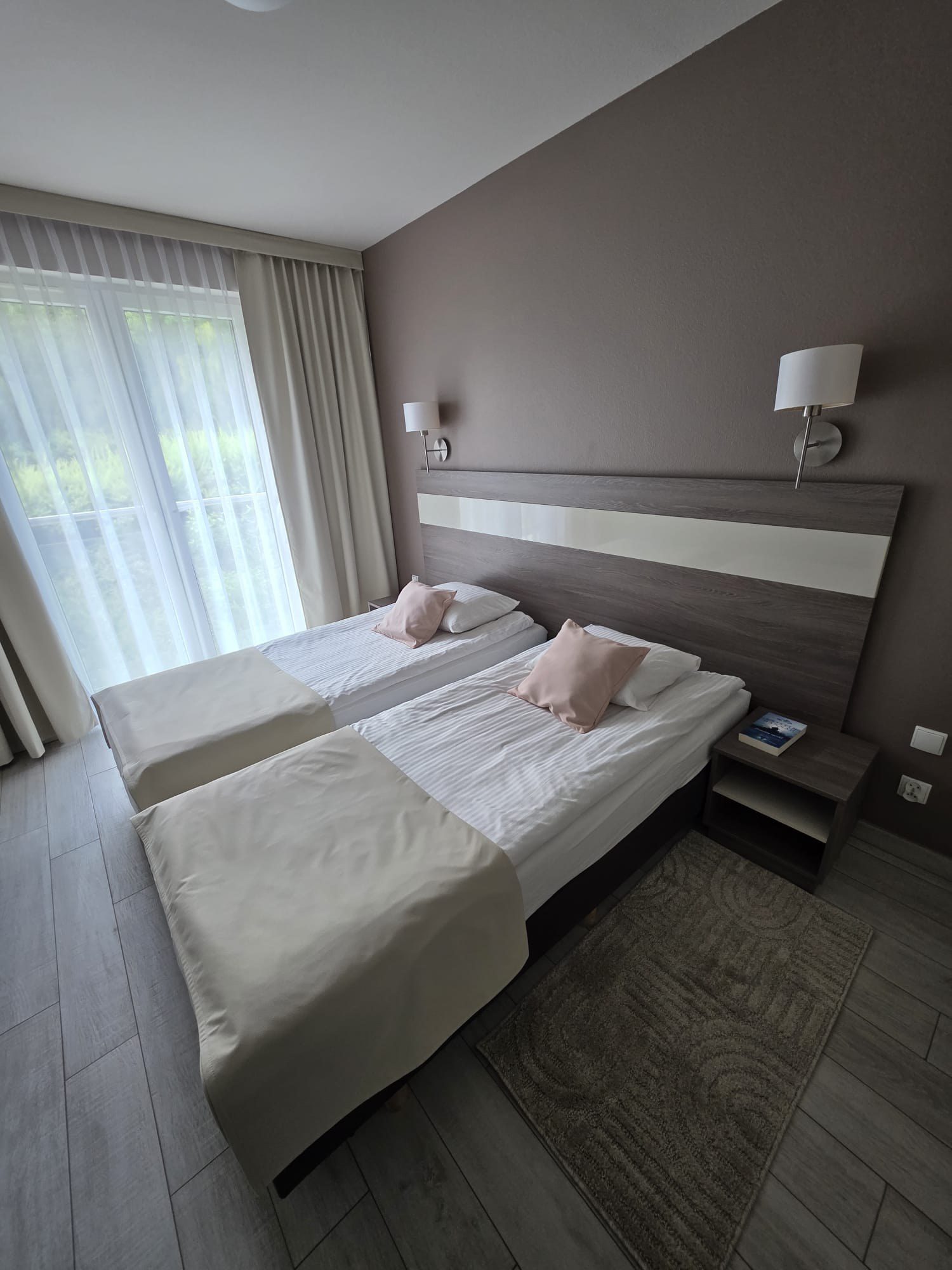 Sypialnia apartamentu Bormio 25 w Siennej z oknem i widokiem na góry